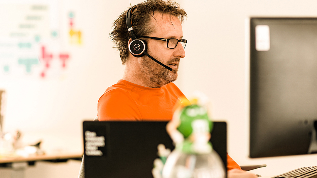 Mitarbeiter mit Headset arbeitet am Computer