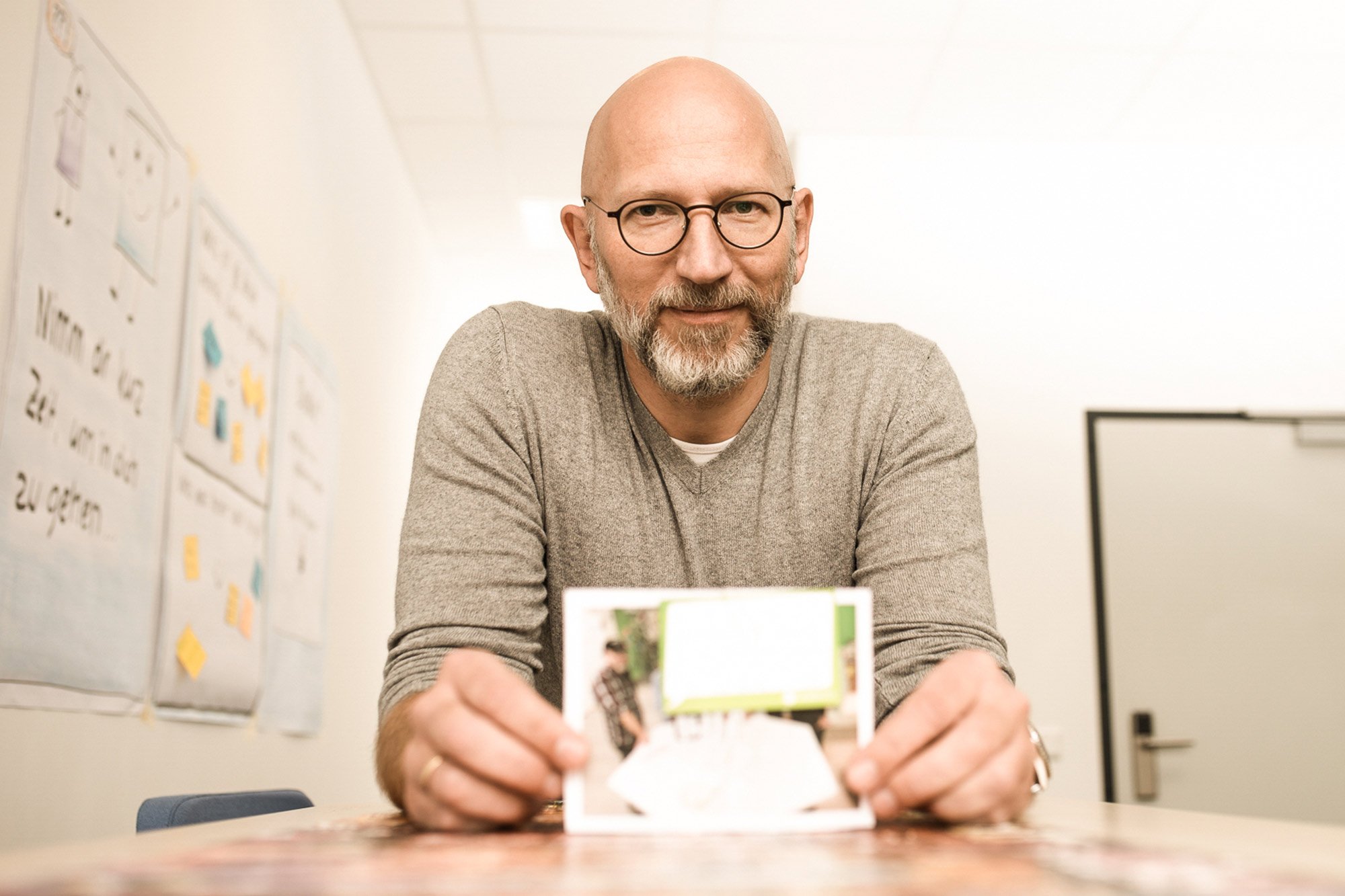 Mann mit Brille und Bart zeigt ein Bild