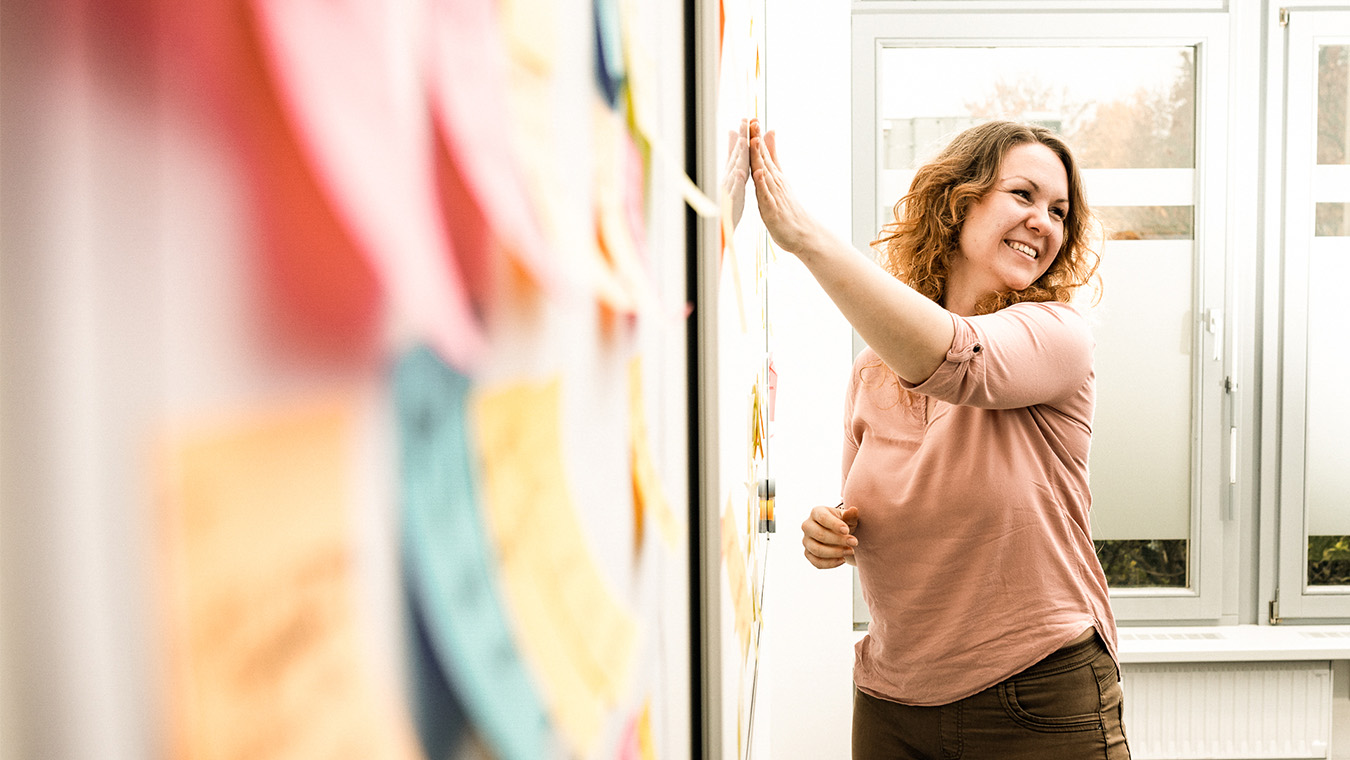 Frau mit am Whiteboard mit Postits