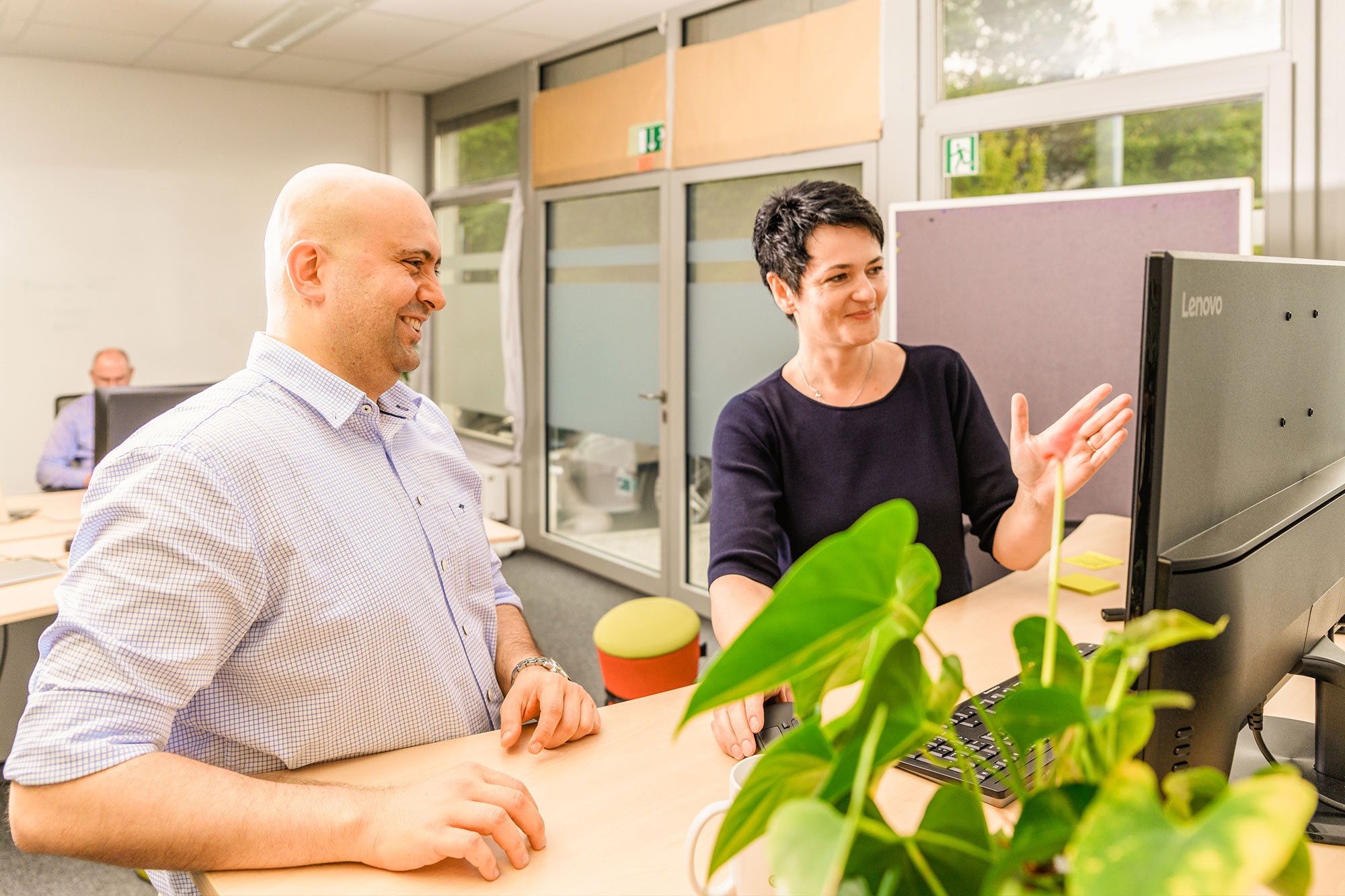Mann und Frau arbeiten zusammen vor PC